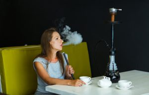 Beautiful Woman Smoking A Hookah And Drinking Tea In A Cafe