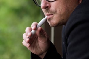 Caucasian Man Smoking Modern Hybrid Cigarette Device Outdoor